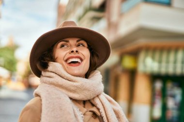 Şık giyinen genç İspanyol kadın şehirde dikiliyor..