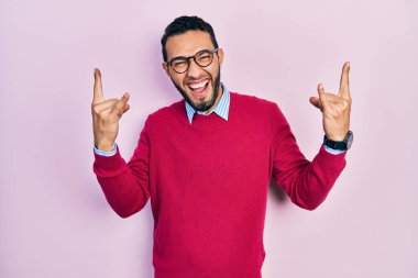 Sakallı, iş gömleği giyen ve gözlüklü çılgın bir ifadeyle bağıran, elleri havada rock sembolü yapan İspanyol bir adam. Müzik yıldızı. ağır müzik konsepti. 