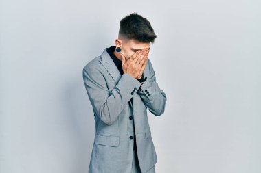 Kulakları genişlemiş, iş ceketi giymiş, suratını ellerle örten ve ağlayan beyaz bir çocuk. depresyon kavramı. 