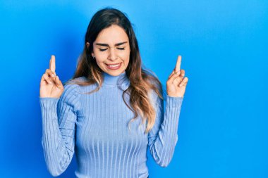 Günlük kıyafetler giyen genç İspanyol kız umut ve gözlerin kapalı gülümseyerek bana işaret etti. Şans ve batıl inançlar. 