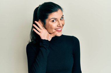 Günlük kıyafetler giyen, ağzı kulaklarında gülümseyen dedikoduları ve dedikoduları dinleyen genç İspanyol kadın. Sağırlık kavramı. 