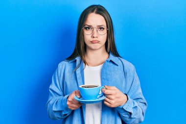 Genç İspanyol kız bir fincan kahve içiyor. Depresyonda ve üzüntüden ağlıyor. Kızgın ve korkmuş. hüzünlü ifade. 