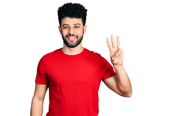 年轻的阿拉伯男子 留着胡子 穿着休闲的红色T恤 手指头指向三号 面带微笑 自信而快乐 — 图库照片