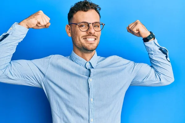 Ung Latinamerikan Klädd Vardagskläder Och Glasögon Som Visar Armmusklerna Leende — Stockfoto