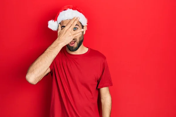 Joven Hombre Hispano Con Sombrero Navidad Asomándose Shock Cubriendo Cara — Foto de Stock
