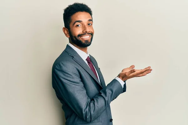 ビジネススーツとネクタイを身に着けている髭を生やしたハンサムなヒスパニック系の男は コピースペースを示す手を脇に指して 広告を提示笑顔興奮幸せ — ストック写真