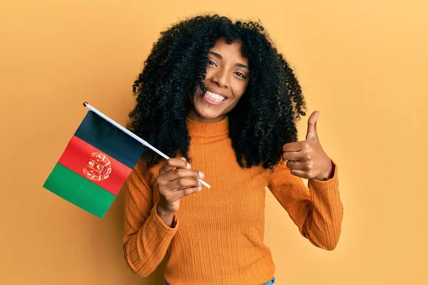 Африканская Американка Афро Волосами Держащая Афганский Флаг Улыбаясь Счастливой Позитивной — стоковое фото