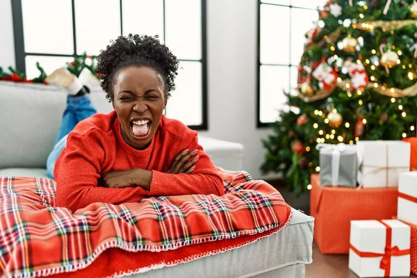 Jovem Afro Americana Deitada Sofá Perto Árvore Natal Com Língua — Fotografia de Stock