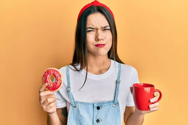 Jovem Hispânica Comendo Donut Bebendo Café Soprando Bochechas Com Cara — Fotografia de Stock