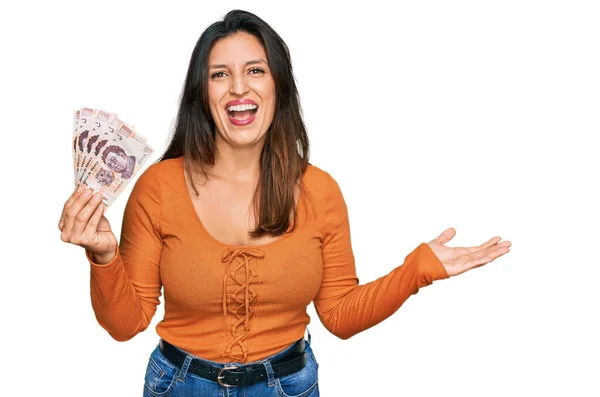 Beautiful Hispanic Woman Holding Mexican Pesos Celebrating Victory Happy Smile — Zdjęcie stockowe