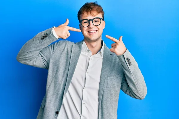 エレガントな服と眼鏡を身に着けている若い白人男性は 陽気な表情と指の歯と口で指して笑っています 歯の健康の概念 — ストック写真