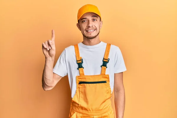 Hispanic Ung Man Bär Händig Uniform Visar Och Pekar Upp — Stockfoto