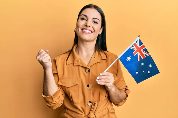 若いブルネットの女性を保持オーストラリアのフラグは誇りに思って叫んで 勝利と成功を祝います非常に興奮して上げ腕 — ストック写真