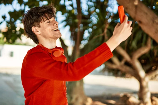 Genç İspanyol gülümseyen adam şehrin akıllı telefonunda selfie çekerken mutlu oluyor..