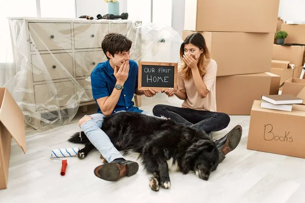 Pasangan Muda Kaukasia Dengan Anjing Memegang Papan Tulis Rumah Pertama — Stok Foto