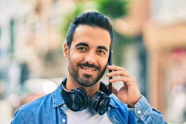 Genç İspanyol adam gülümsüyor. Şehirdeki akıllı telefondan konuşuyor..