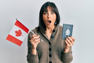 Elinde Kanada bayrağı ve pasaportu olan genç İspanyol kadın şaşkınlık ve şaşkınlık dolu bir ifade, korku ve heyecan dolu bir yüz ile şoka uğradı.. 