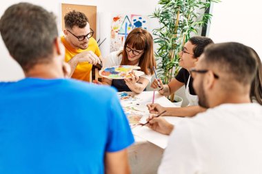 Resim stüdyosunda çizim yapan bir grup insan..