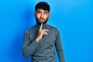 Balıkçı yaka kazak giyen, sakallı Arap bir adam şüphe üzerine yoğunlaşmıştı. Parmakları çenesinde ve yukarı bakıyordu. 