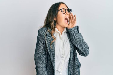 Genç esmer bir kadın akıllı telefondan konuşuyor ve elleri ve kolları havada kafası karışık bir ifade takınıyor. şüphe kavramı. 