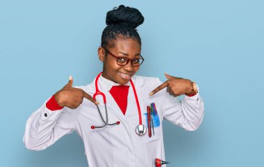 Genç Afro-Amerikan kadın doktor üniforması ve steteskop giyiyor. Kendine güvenen, gülümseyen, kendini gururlu ve mutlu gösteren.. 