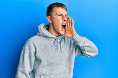 Sıradan bir eşofman üstü giyen genç beyaz bir adam el ele tutuşarak bağırıyor ve çığlık atıyordu. iletişim konsepti. 