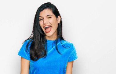 Gündelik kıyafetler giyen genç İspanyol kadın kameraya seksi bir ifadeyle bakıyor, neşeli ve mutlu bir yüzle.. 