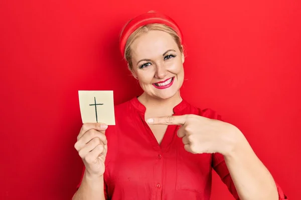 Jonge Blonde Vrouw Houden Katholieke Kruis Herinnering Glimlachen Gelukkig Wijzend — Stockfoto