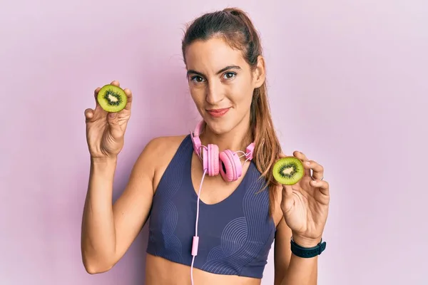 Young Beautiful Woman Wearing Gym Clothes Holding Slice Kiwi Relaxed — ストック写真