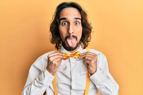 Jovem Hispânico Homem Vestindo Hipster Elegante Olhar Segurando Bowtie Furar — Fotografia de Stock