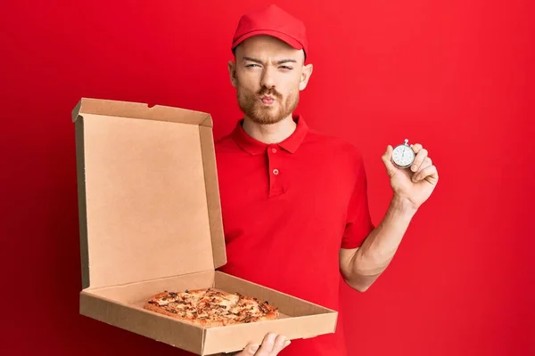 Fiatal Vörös Hajú Férfi Egyenruhában Pizzás Dobozzal Visszaszámlálós Órával Kezében — Stock Fotó