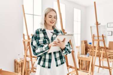 Resim stüdyosunda gülümseyen genç sanatçı kız..