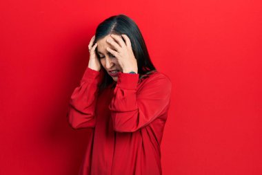 Orta yaşlı İspanyol kadın gündelik giysiler giyiyor. Baş ağrısı çekiyor, çaresiz ve stresli. Çünkü acı ve migren ağrısı var. Eller başının üstünde.. 