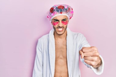 Bornoz ve duş başlığı takan genç İspanyol adam göz torbaları kullanıyor. Sinirli ve hayal kırıklığına uğramış bantlar öfkeyle bağırıyor. Öfkeyle ve el kaldırarak deli gibi bağırıyor. 