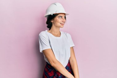 Kafkaslı genç bir kadın yüzünde gülümsemeyle yüzünü yana doğru çeviriyor, doğal bir ifade. Kendinden emin gülen. 