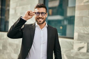 Genç İspanyol işadamı gülümseyerek şehirde mutlu mesut duruyor..