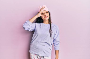 Ortadoğulu güzel bir kadın uyku maskesi takmış ve pijamayla gülümsüyor. Mutluluktan gülümsüyor. 