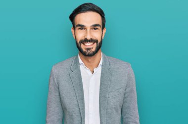 Yüzünde mutlu ve havalı bir gülümseme olan iş kıyafetleri giyen genç İspanyol bir adam. şanslı kişi. 