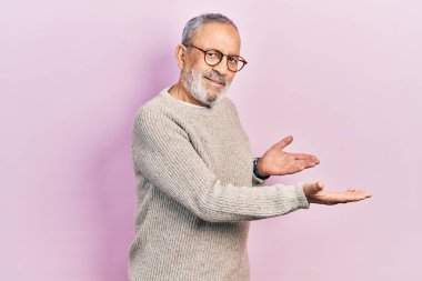 Sakallı, sıradan bir süveter ve gözlüklü yakışıklı bir adam gülümseyerek içeri girmeye davet ediyor. 