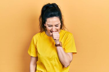 Günlük kıyafetler giyen genç İspanyol kadın kendini iyi hissetmiyor ve soğuk algınlığı veya bronşitin belirtisi olarak öksürüyor. sağlık hizmeti kavramı. 