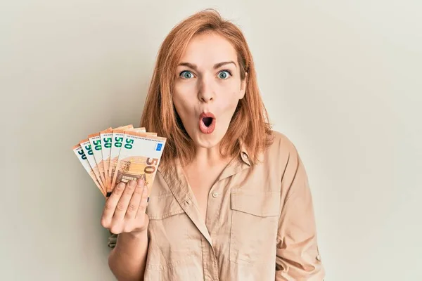 Young Caucasian Woman Holding Bunch Euro Banknotes Scared Amazed Open — Stock Photo, Image