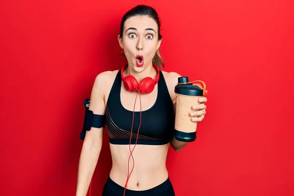 Young Hispanic Girl Wearing Sport Clothes Drinking Protein Shake Scared — ストック写真