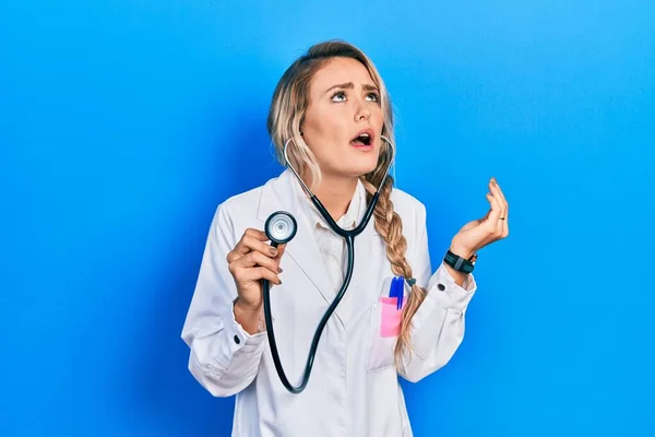 Mulher Bonita Jovem Médico Loira Segurando Estetoscópio Louco Louco Gritando — Fotografia de Stock