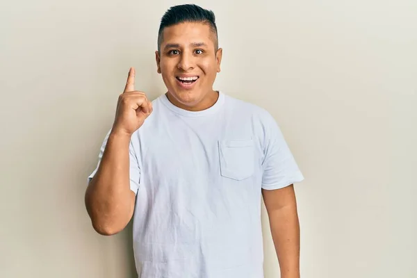 Jovem Latino Vestindo Casual Shirt Branca Apontando Dedo Para Cima — Fotografia de Stock