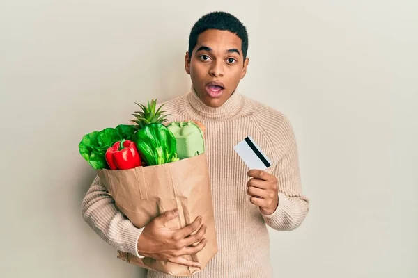 Joven Hombre Hispano Guapo Sosteniendo Comestibles Tarjetas Crédito Asustado Sorprendido —  Fotos de Stock