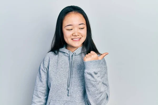 Молодая Китайская Девушка Повседневной Одежде Улыбается Счастливым Лицом Указывает Сторону — стоковое фото