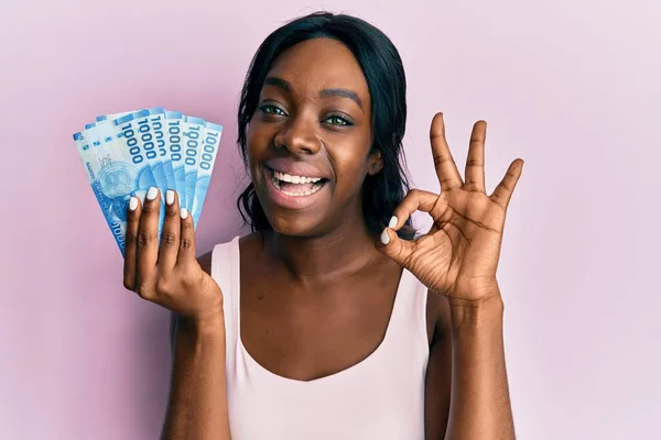 Jovem Afro Americana Segurando 10000 Pesos Chilenos Fazendo Sinal Com — Fotografia de Stock