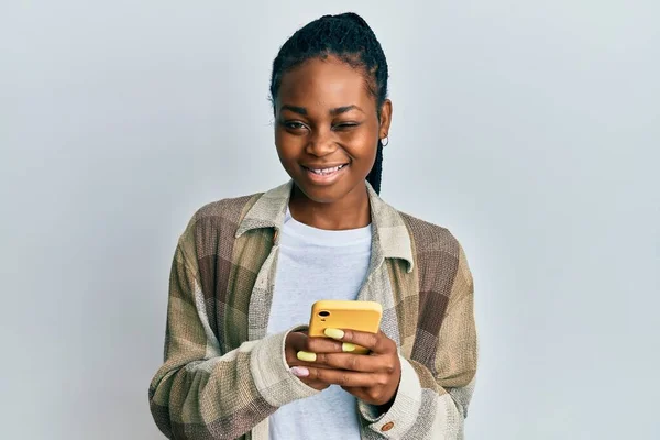 Молодая Африканская Американка Помощью Смартфона Подмигивает Глядя Камеру Сексуальным Выражением — стоковое фото
