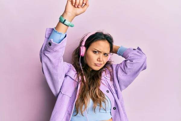 Chica Hispana Joven Bailando Escuchando Música Usando Auriculares Escépticos Nerviosos —  Fotos de Stock