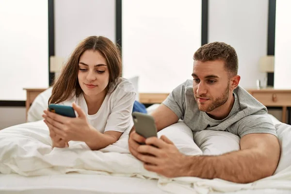 Kafkasyalı Genç Bir Çift Evde Yatarken Akıllı Telefon Kullanıyor — Stok fotoğraf